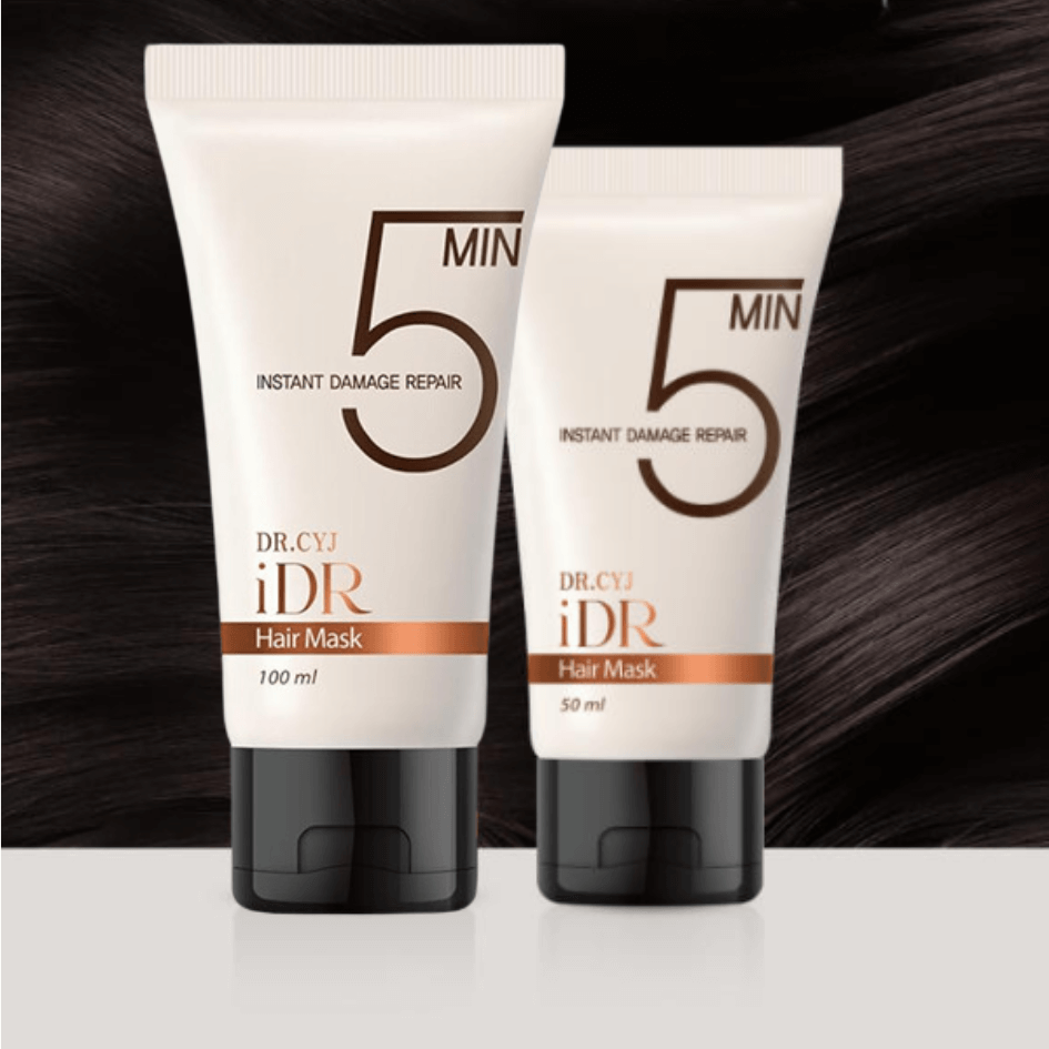 Two tubes of Dr. CYJ iDR Hair Mask in 50 ml and 100 ml sizes, white tubes with orange accents, set against a sleek dark background.