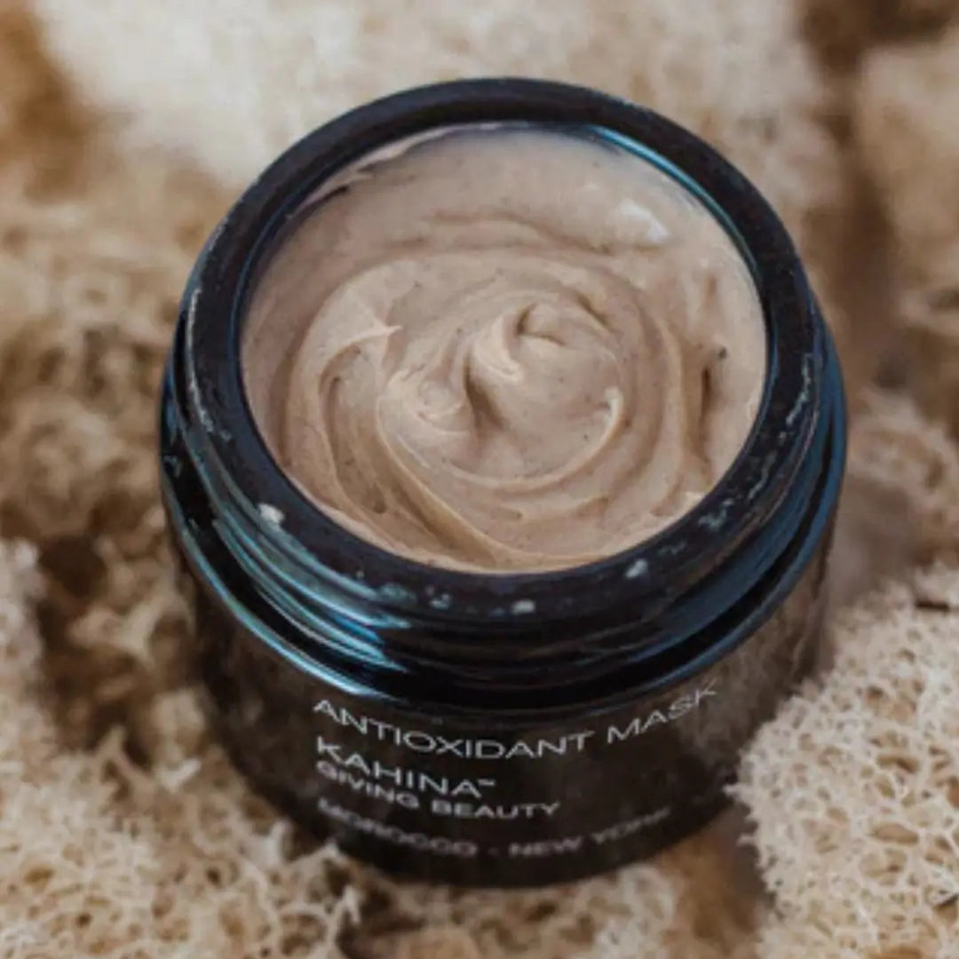 Open jar of Kahina Antioxidant Mask showing creamy texture, set against a natural backdrop, emphasizing its skin smoothing and nourishing benefits.