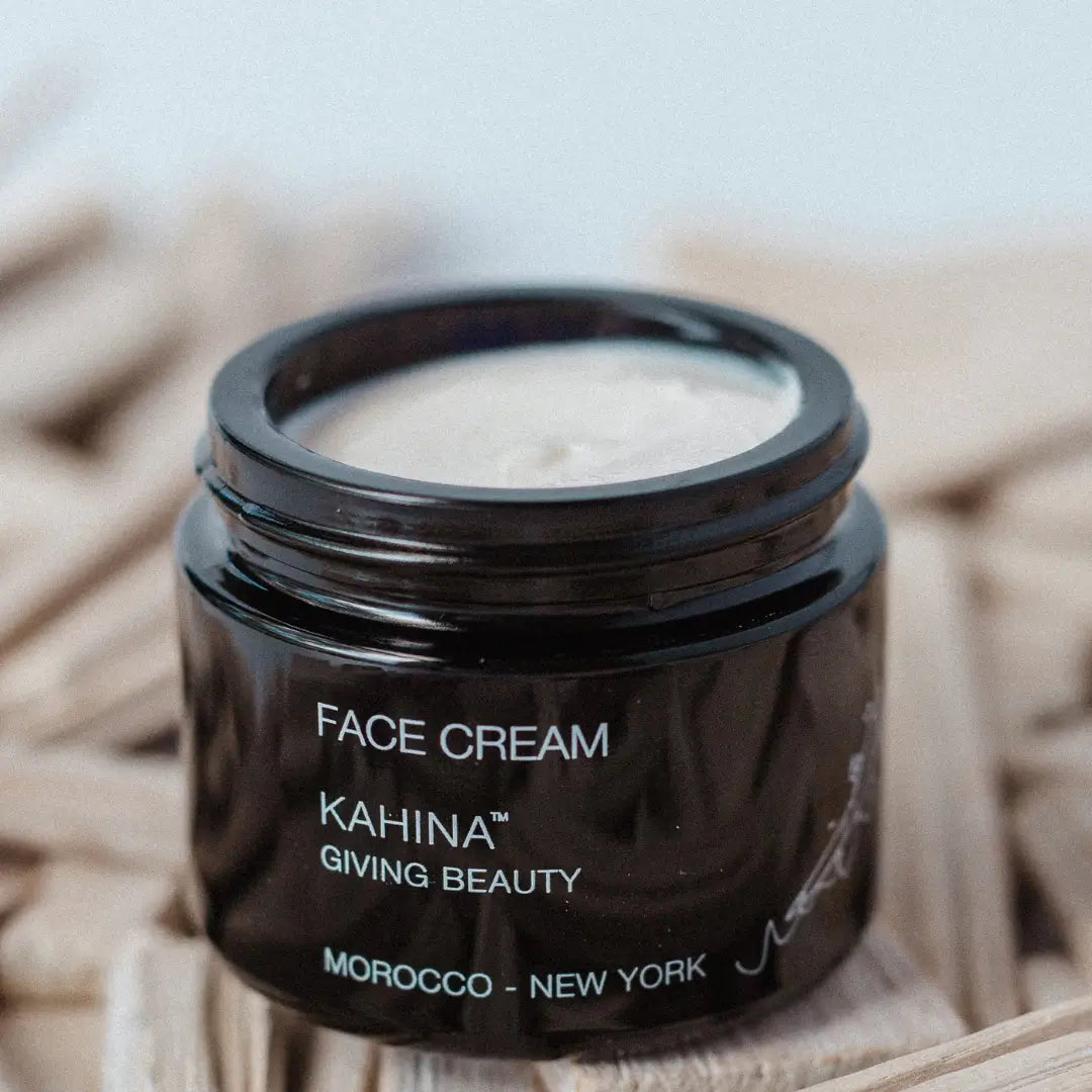 Open jar of Kahina Giving Beauty Face Cream, displaying its rich texture against a natural fiber background, perfect for enhancing skin elasticity and hydration.