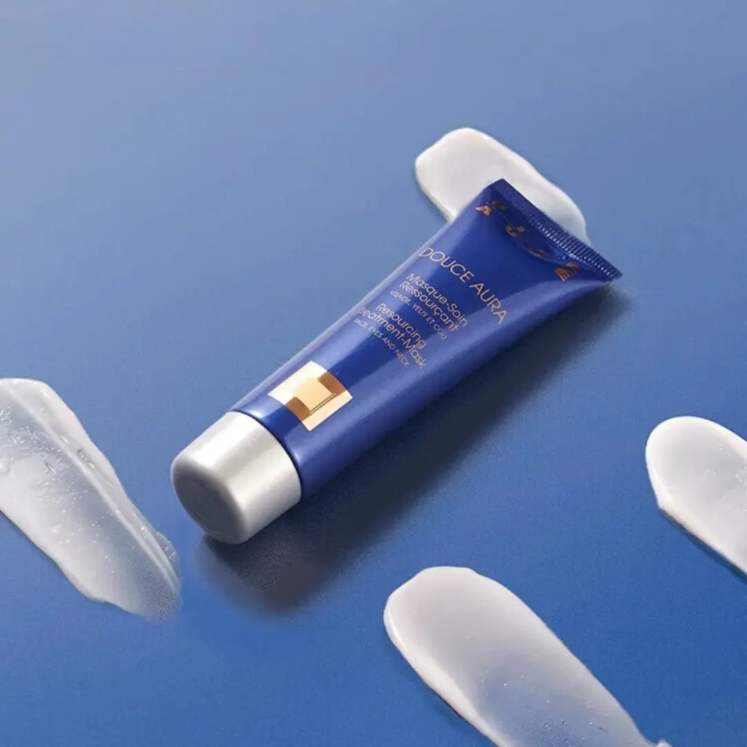 Pier Auge Douce Aura mask tube with spilled contents on blue background, emphasizes hydration and skin elasticity.